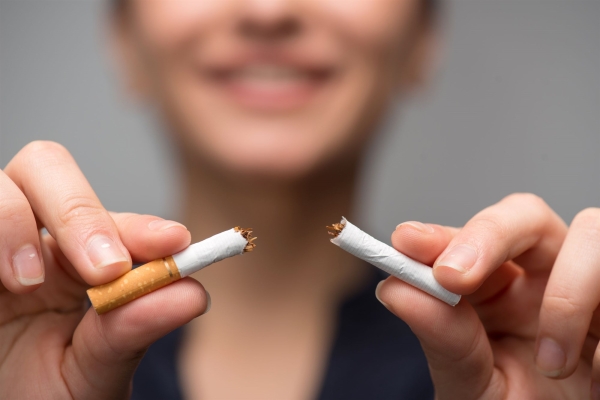 A woman breaking a cigarette in half