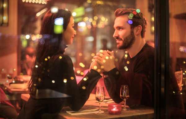A photo of a couple in a restaurang holding hands and looking at each other